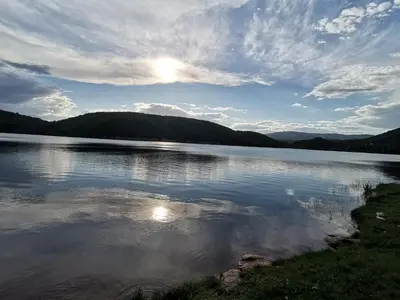 a view of a lake with the sun reflecting on the water at Apartman ST.Nedeljkovic Sokobanja in Soko Banja