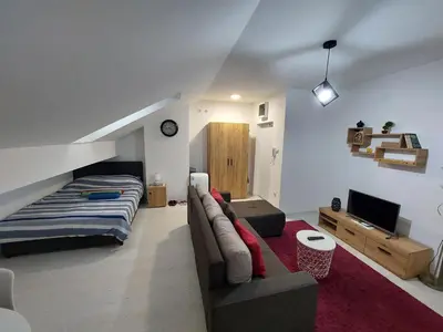 a living room with a couch and a bed at Apartman ST.Nedeljkovic Sokobanja in Soko Banja