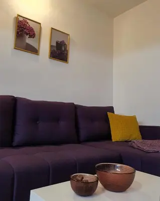 a living room with a purple couch and a table at LILAC Apartment in Vrnjačka Banja