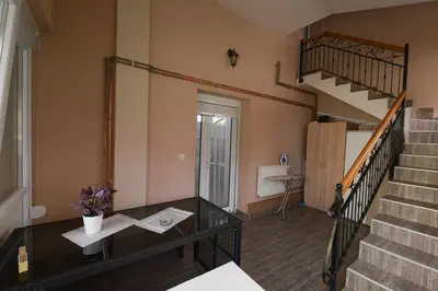 a living room with a staircase and a table at Capitol Apartmani in Vrnjačka Banja