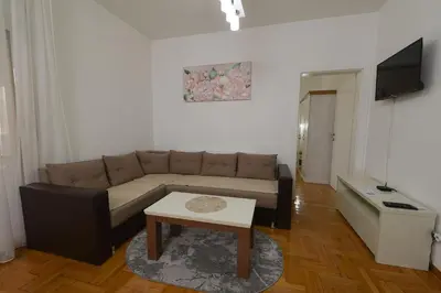 a living room with a couch and a table at Capitol Apartmani in Vrnjačka Banja