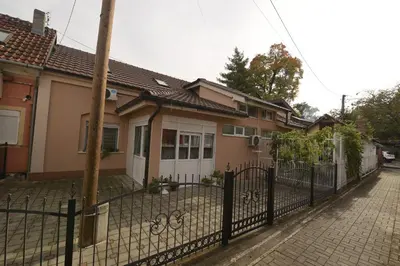 a house with a fence in front of it at Capitol Apartmani in Vrnjačka Banja