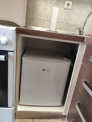 a dishwasher in a kitchen under a counter at Modern cozy apartment in Niš
