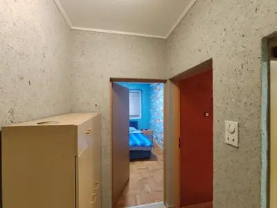a room with a refrigerator and a room with a bedroom at Modern cozy apartment in Niš