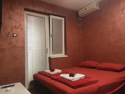 a bedroom with a red bed with towels on it at Modern cozy apartment in Niš