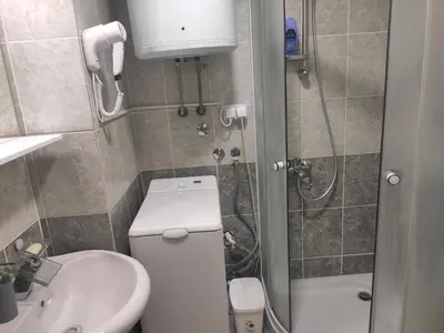 a bathroom with a toilet and a sink and a shower at Modern cozy apartment in Niš