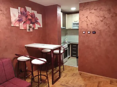 a kitchen with a bar in the middle of a room at Modern cozy apartment in Niš