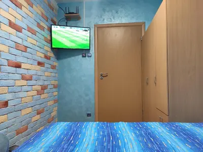 a bedroom with a bed and a tv on a brick wall at Modern cozy apartment in Niš