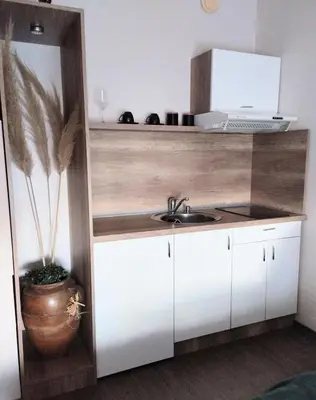 a kitchen with white cabinets and a sink at Studio City day in Jagodina
