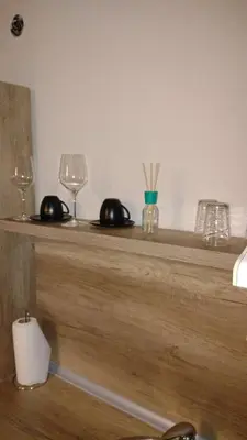 a wooden counter with two glasses and a candle at Studio City day in Jagodina
