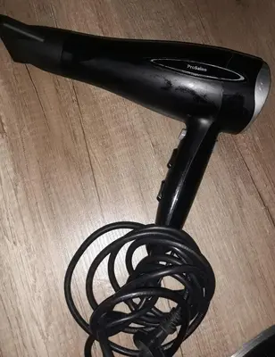 a black hair dryer with a cord on a table at Studio City day in Jagodina