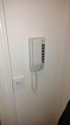 a white phone hanging on a wall at Studio City day in Jagodina