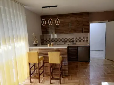 a kitchen with a island with yellow chairs in it at Apartman Jasna in Vrnjci