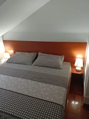 a bedroom with a bed with two lamps on it at Apartman Jasmin in Vrnjačka Banja