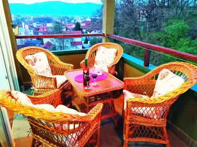 a balcony with wicker chairs and a table with a view at Apartman Jasmin in Vrnjačka Banja