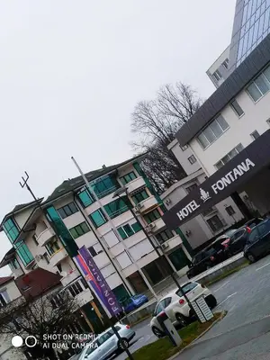 a large building with cars parked in front of it at Apartman Jasmin in Vrnjačka Banja