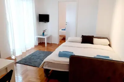 a bedroom with a large bed and a television at Smeštaj Voli - Apartman u centru Sokobanje in Soko Banja