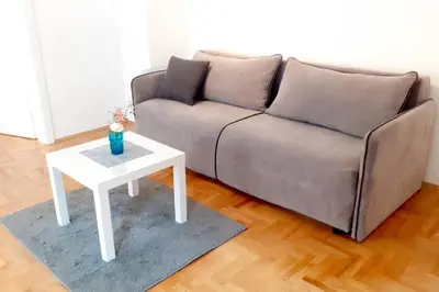 a living room with a couch and a white coffee table at Smeštaj Voli - Apartman u centru Sokobanje in Soko Banja