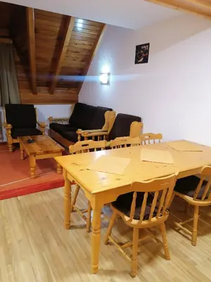 a living room with a wooden table and chairs at Guest House Villa Rankovic in Brzeće