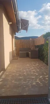 a patio with a bench and a wooden fence at AquaLux 2 in Soko Banja