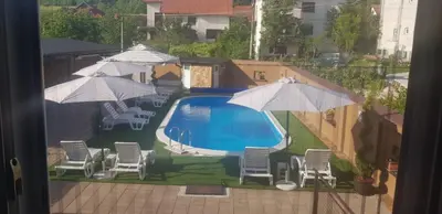 a view of a swimming pool with chairs and umbrellas at AquaLux 2 in Soko Banja