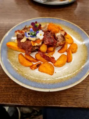 a plate of food on a wooden table at Apartman Esperanza in Vrnjačka Banja