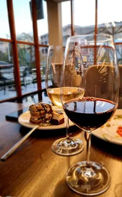 two glasses of wine sitting on a wooden table at Apartman Esperanza in Vrnjačka Banja