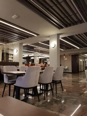 a restaurant with white chairs and tables in a building at Apartman Esperanza in Vrnjačka Banja
