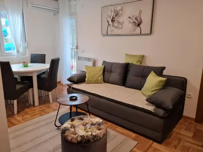 a living room with a black couch and a table at Apartman TIM LUX 2 in Vrnjačka Banja