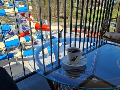 a cup of coffee on a glass table on a balcony at Apartman TIM LUX 2 in Vrnjačka Banja