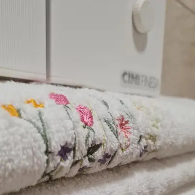 a towel with flowers on it sitting on a shelf at Apartman TIM LUX 1 in Vrnjačka Banja