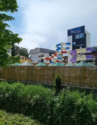a fence with umbrellas in front of a building at Apartman TIM LUX 1 in Vrnjačka Banja