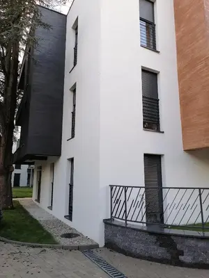 a white building with black windows and a balcony at Ramonda Lux apartman in Vrnjačka Banja