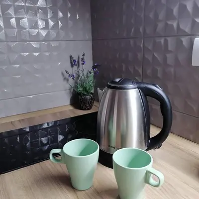 a tea kettle and two cups on a counter at Ramonda Lux apartman in Vrnjačka Banja
