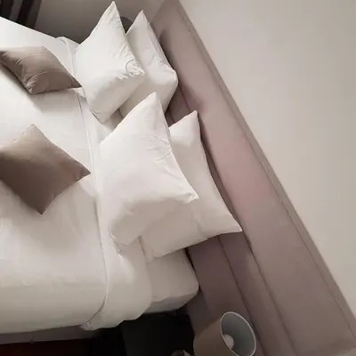 a pile of pillows on a bed in a room at Apartman Ibarstar in Vrnjačka Banja