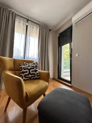 a living room with a chair and a window at Enigma in Vrnjačka Banja