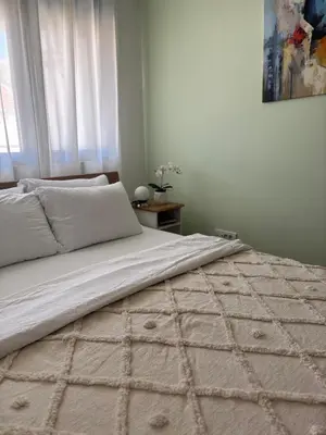 a bedroom with a large bed with a blanket at Enigma in Vrnjačka Banja