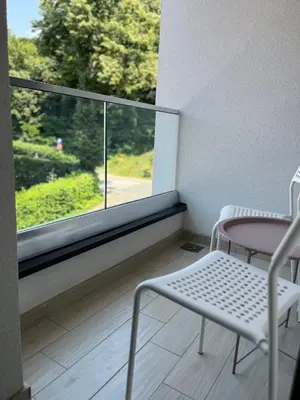 a balcony with a table and chairs and a window at Enigma in Vrnjačka Banja