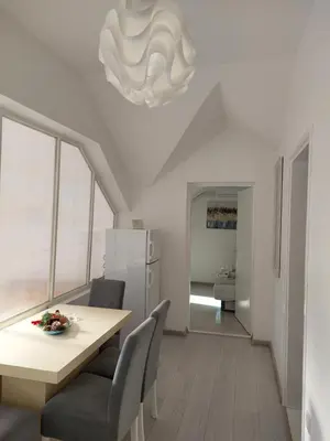 a kitchen and dining room with a table and a chandelier at Apartman Andrijana 1 in Soko Banja