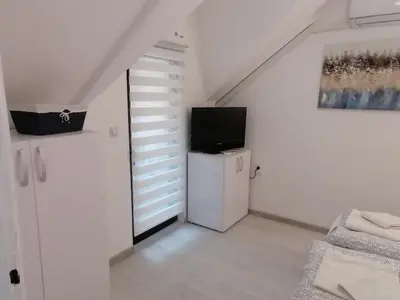 a living room with a television and a small refrigerator at Apartman Andrijana 1 in Soko Banja