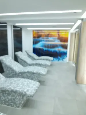 a row of chairs in a room with a painting at President Kop - Apartman A21 in Kopaonik