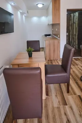 a dining room with a table and two chairs at Apartmani Tvins in Soko Banja