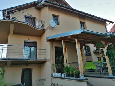 a house with a balcony and a patio at Apartmani Tvins in Soko Banja