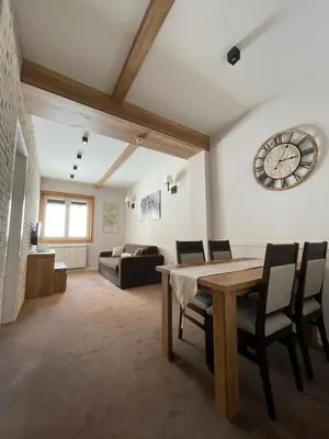 a living room with a wooden table and chairs at Central Residence by Župa in Kopaonik