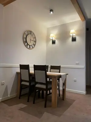 a dining room with a table and a clock on the wall at Central Residence by Župa in Kopaonik