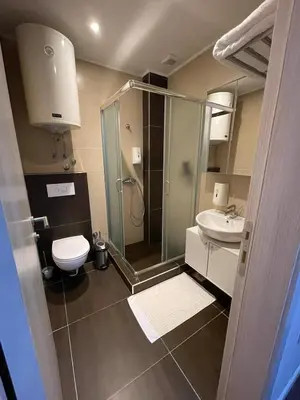 a bathroom with a shower and a toilet and a sink at Central Residence by Župa in Kopaonik