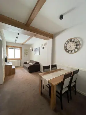 a living room with a table and a couch at Central Residence by Župa in Kopaonik