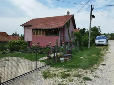 a pink house with a car parked in front of it at Stancic 019 in Zaječar