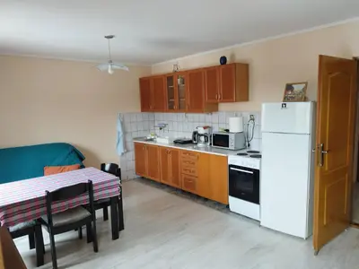 a small kitchen with a table and a white refrigerator at Stancic 019 in Zaječar