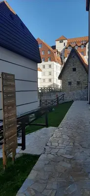 a white building with a sign next to a street at Kraljevi čardaci, apartman 53 u zgradi 7, opcija unutrašnjeg parking mesta in Kopaonik